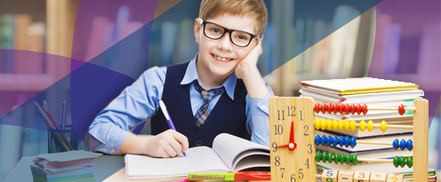 Boy smiling at camera writing in notepad.