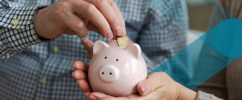 man putting money in piggy bank